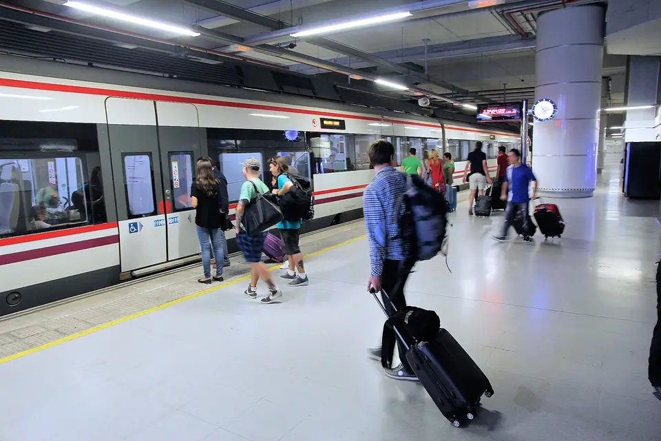 Havalimanı tren istasyonunda bavullarıyla trene binen yolcular, arkadan görünüş